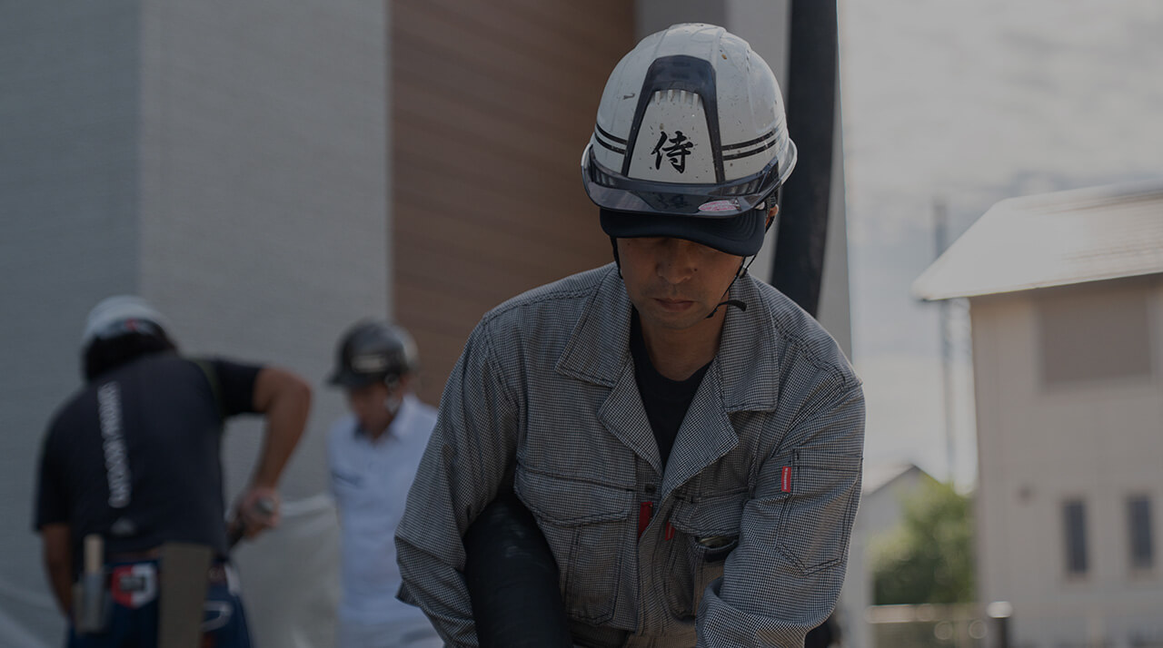 コンクリート圧送の作業中の様子。職人のヘルメットには「侍」の文字。