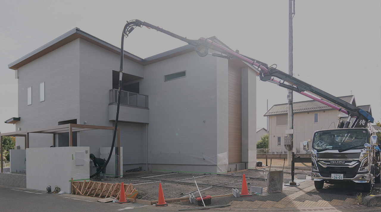 住宅前でコンクリート圧送車が作業している様子