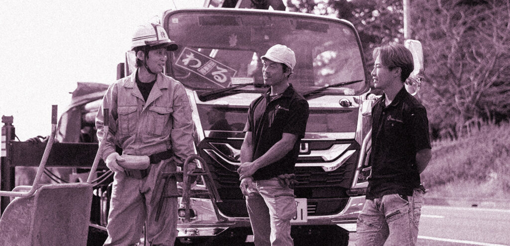 トラックの前で談笑中の職人