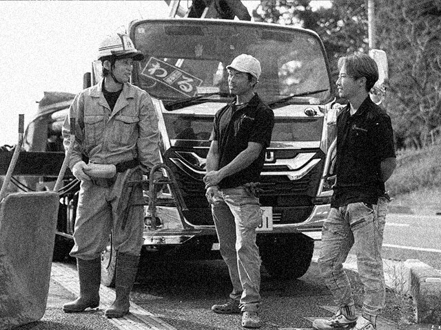 トラックの前で談笑中の職人